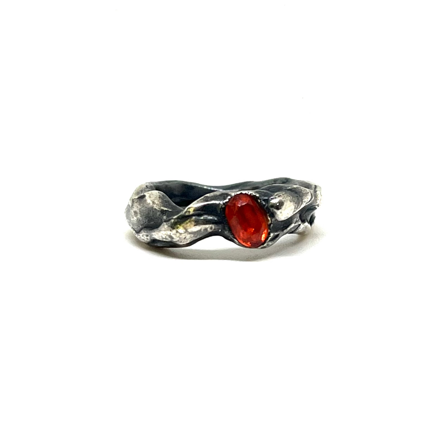 A textured sterling silver ring with a central oval-cut red gemstone, photographed on a plain white background.